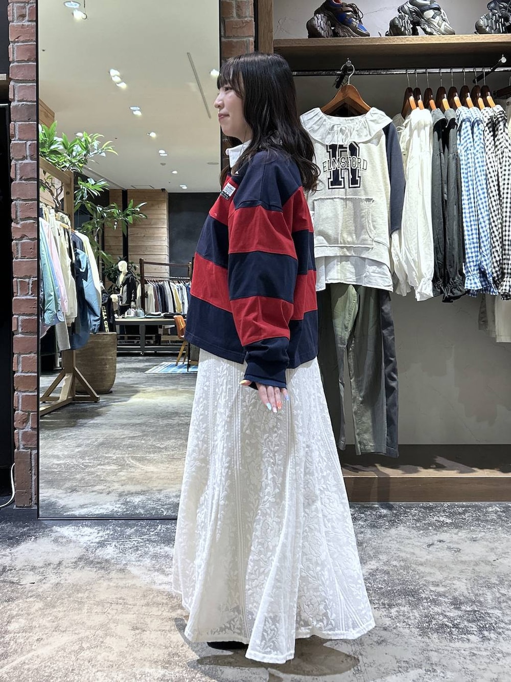 ブルー系のシャツ/ブラウス、ブラック系のパンプス、レッド系のTシャツ/カットソーを着用したレディースの春コーディネートの3枚目の写真