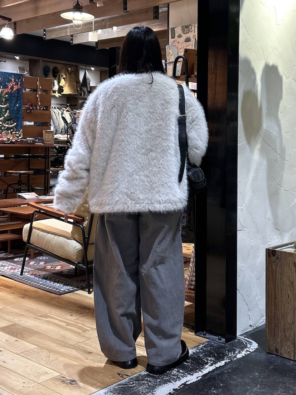 ブラック系のショルダーバッグ、ブラック系のドレスシューズ、ブラック系のTシャツ/カットソーを着用したレディースの冬コーディネートの3枚目の写真