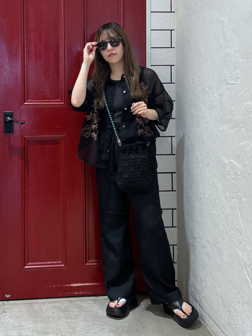 ブラック系のショルダーバッグ、ブラック系のサンダル、ブルー系のシャツ/ブラウスを着用したレディースの夏コーディネートの2枚目の写真