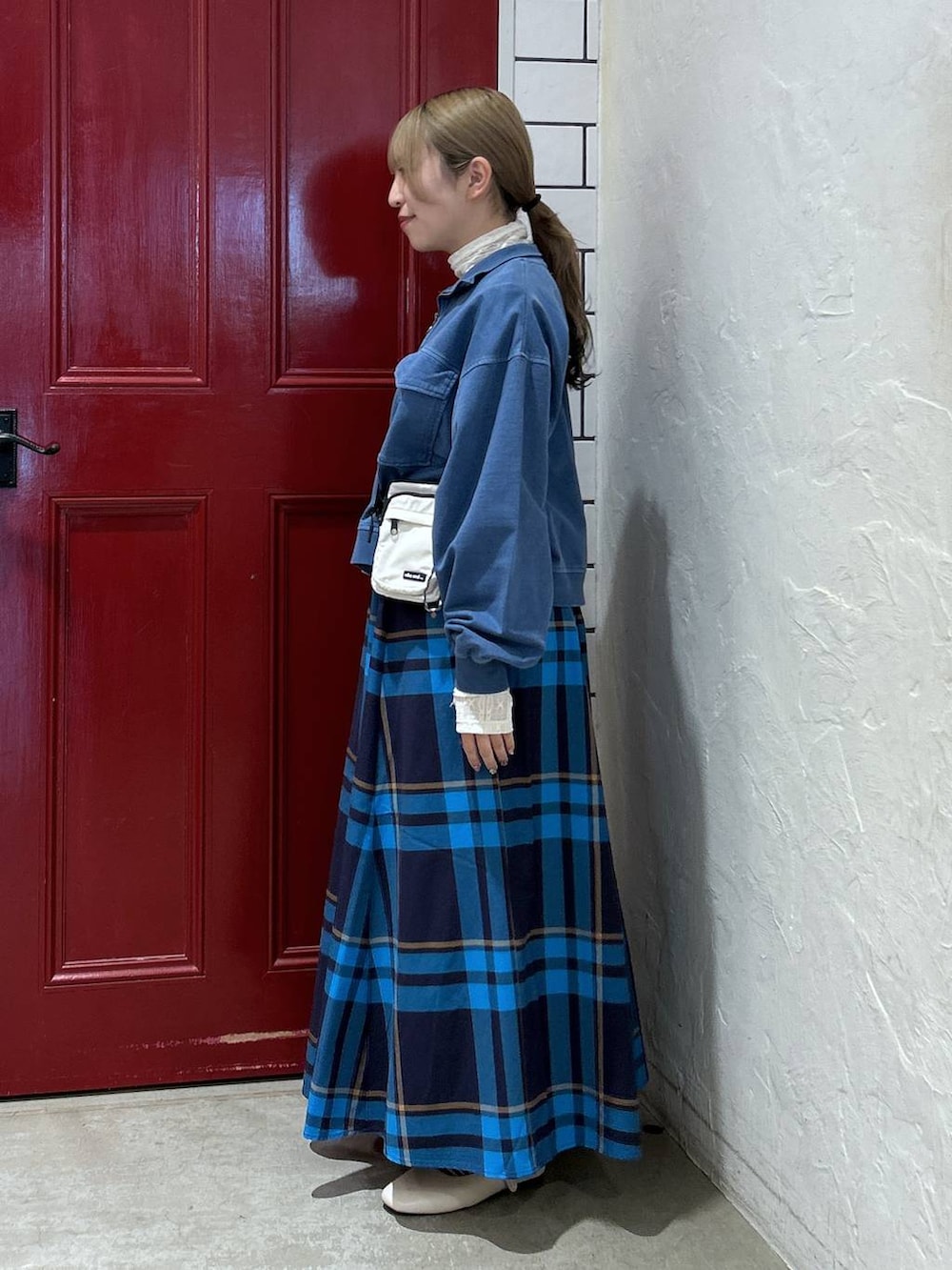 ブルー系のスウェット、ベージュ系のショルダーバッグ、ホワイト系のパンプスを着用したレディースの春コーディネートの2枚目の写真