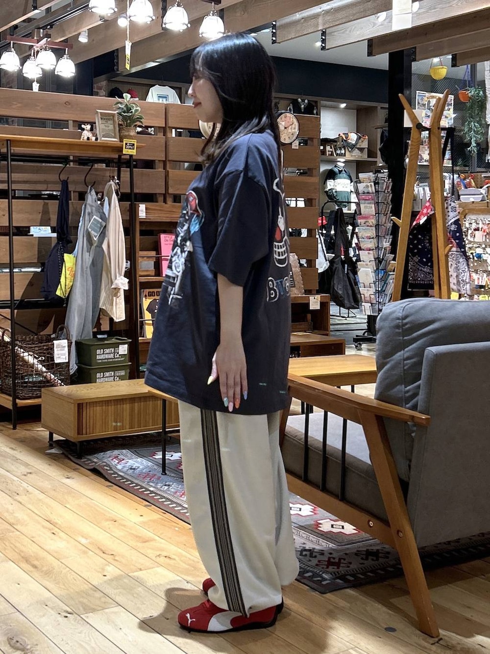 レッド系のスニーカー、ブラック系のショルダーバッグ、ベージュ系のカバーオールを着用したレディースの春コーディネートの7枚目の写真