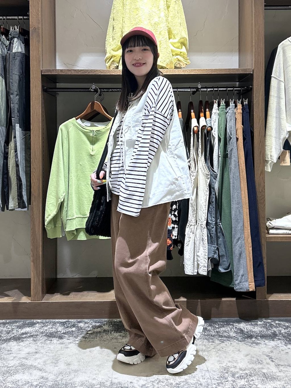 その他のスニーカー、ベージュ系のベスト、ブラック系のトートバッグを着用したレディースの春コーディネートの4枚目の写真