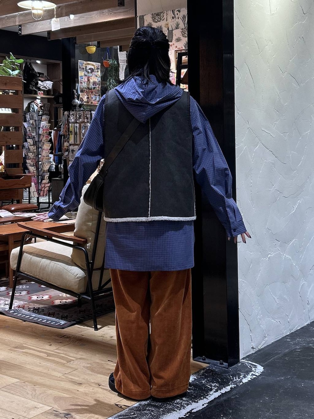 オレンジ系のその他パンツ、ブラウン系のベスト、ブラック系のスニーカーを着用したレディースの秋コーディネートの4枚目の写真