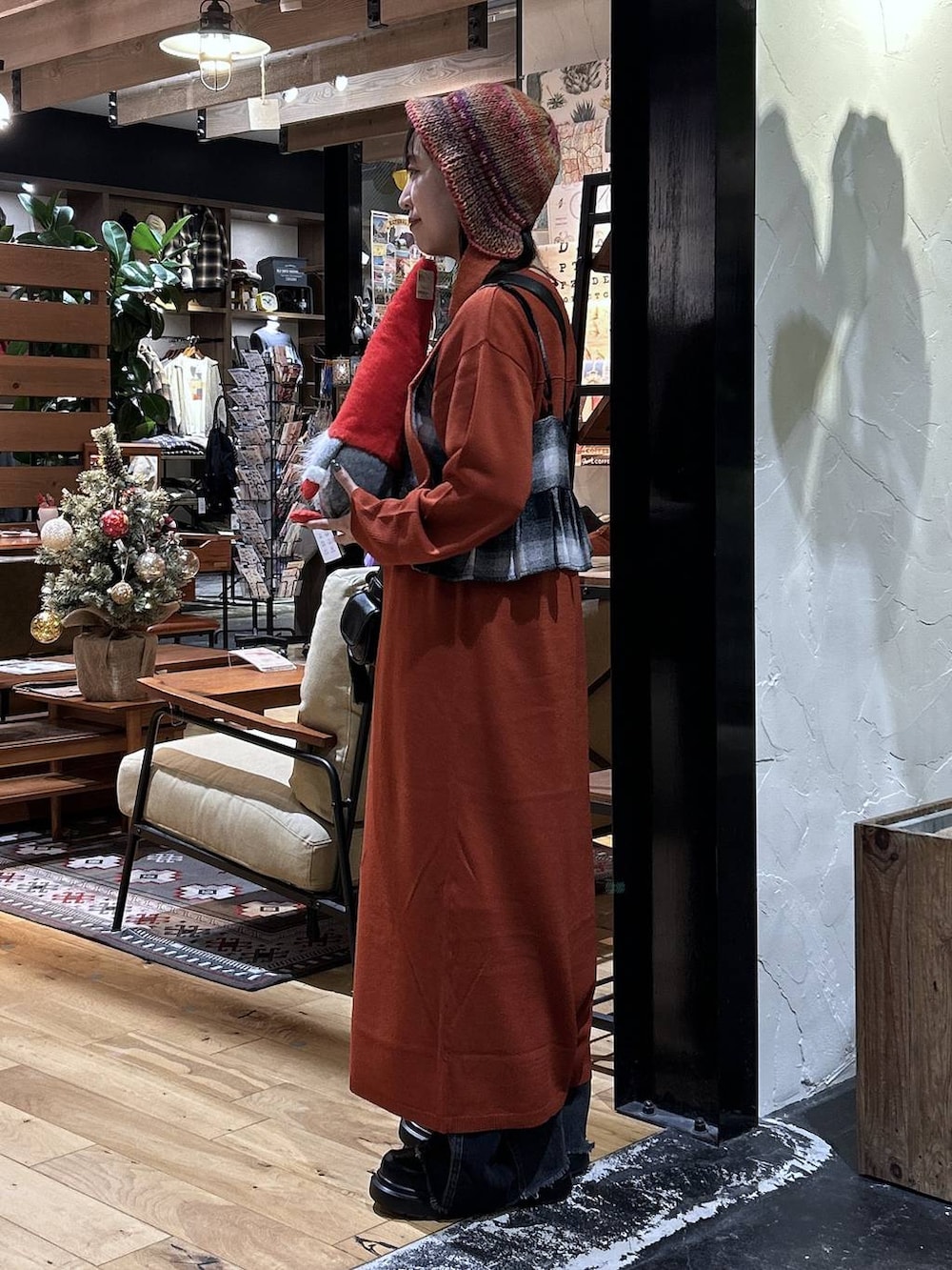 ブラック系のデニムパンツ、ブラック系のキャミソール、ブラック系のショルダーバッグを着用したレディースの秋コーディネートの2枚目の写真