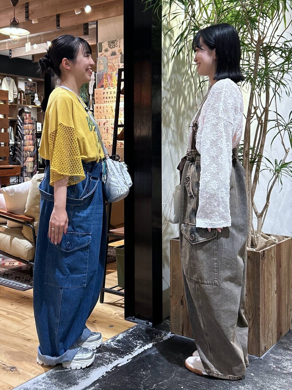 シルバー系のショルダーバッグ、オレンジ系のタンクトップ、シルバー系のスニーカーを着用したレディースの夏コーディネートの2枚目の写真