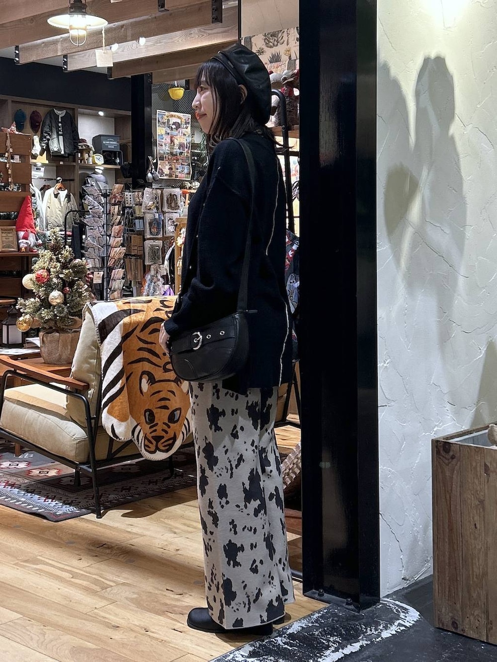 ブラック系のニット/セーター、ベージュ系のその他パンツ、ブラック系のブーツを着用したレディースの秋コーディネートの2枚目の写真