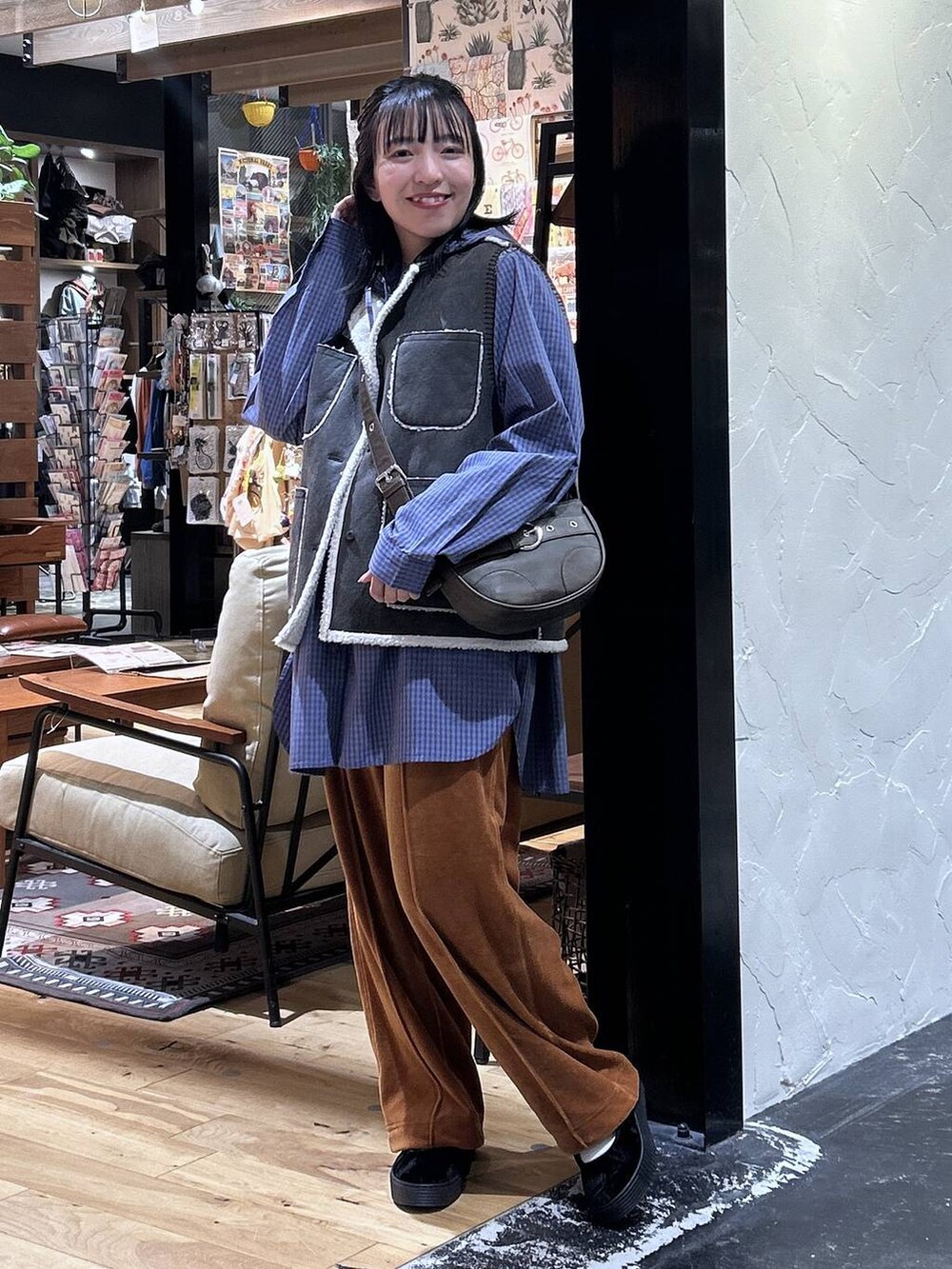 オレンジ系のその他パンツ、ブラウン系のベスト、ブラック系のスニーカーを着用したレディースの秋コーディネートの2枚目の写真