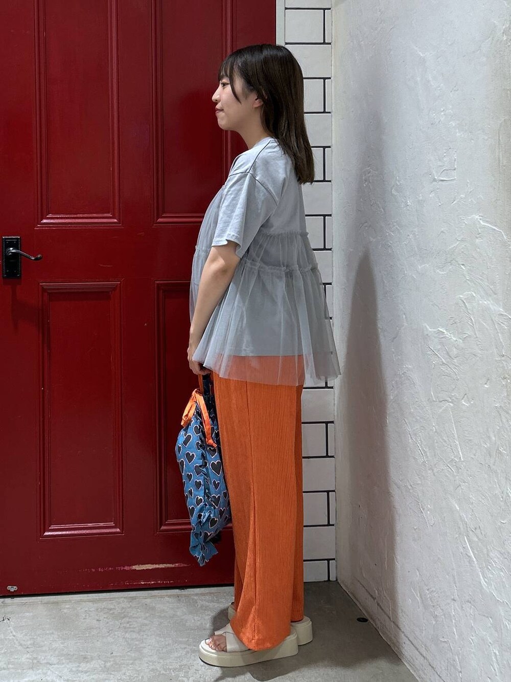 ベージュ系のサンダル、オレンジ系のその他パンツ、ブルー系のトートバッグを着用したレディースの夏コーディネートの2枚目の写真