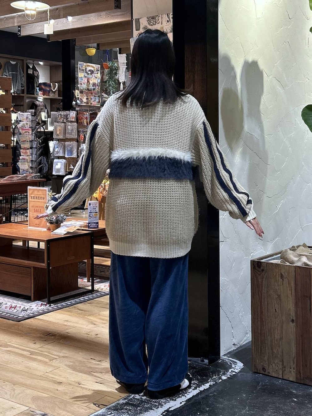 ブラック系のスニーカー、ブルー系のその他パンツ、ベージュ系のカーディガン/ボレロを着用したレディースの冬コーディネートの3枚目の写真