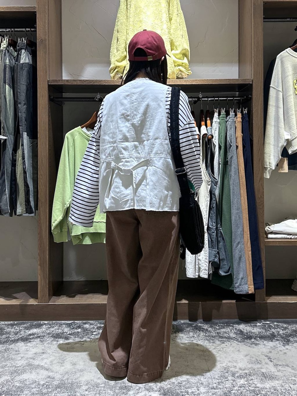 その他のスニーカー、ベージュ系のベスト、ブラック系のトートバッグを着用したレディースの春コーディネートの6枚目の写真