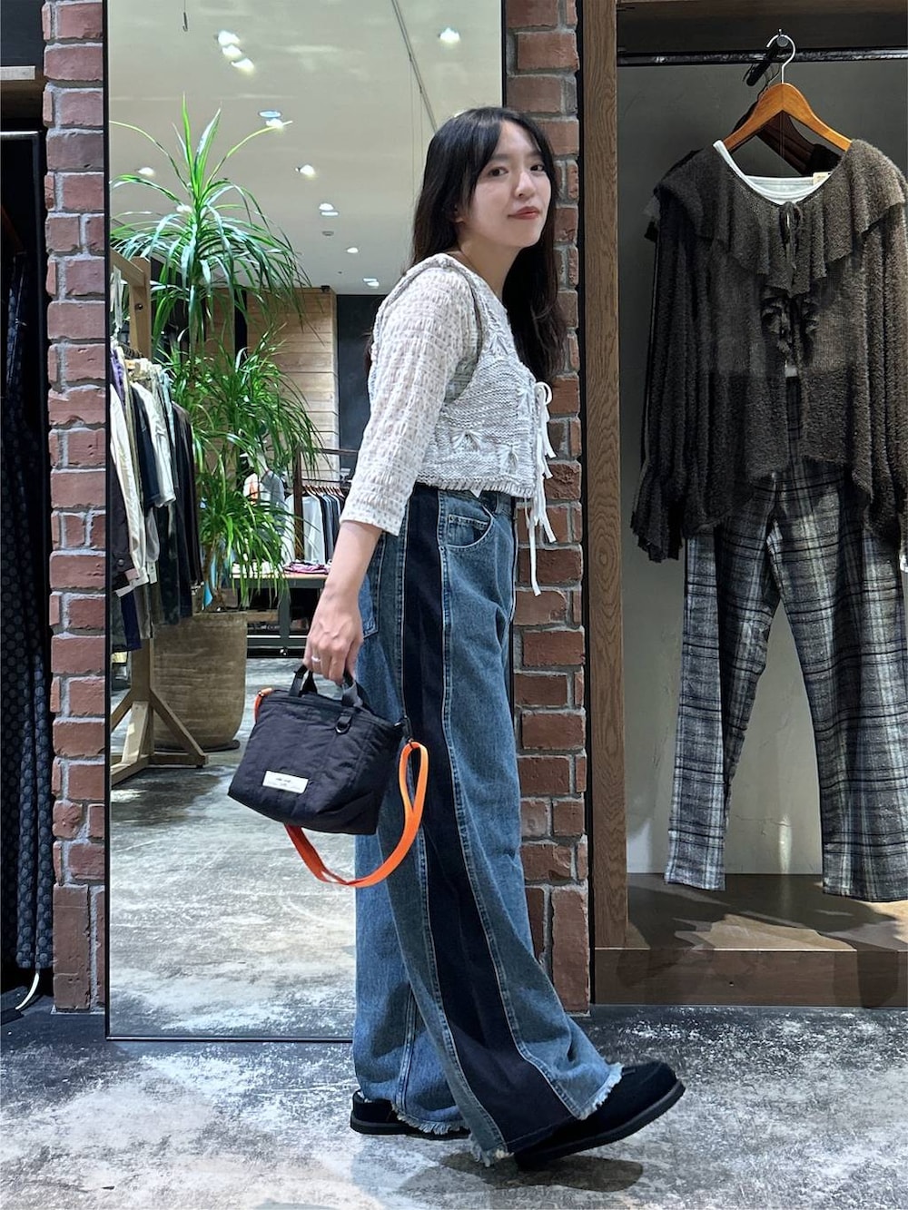 ホワイト系のTシャツ/カットソー、ホワイト系のベスト、ブラック系のトートバッグを着用したレディースの秋コーディネートの4枚目の写真