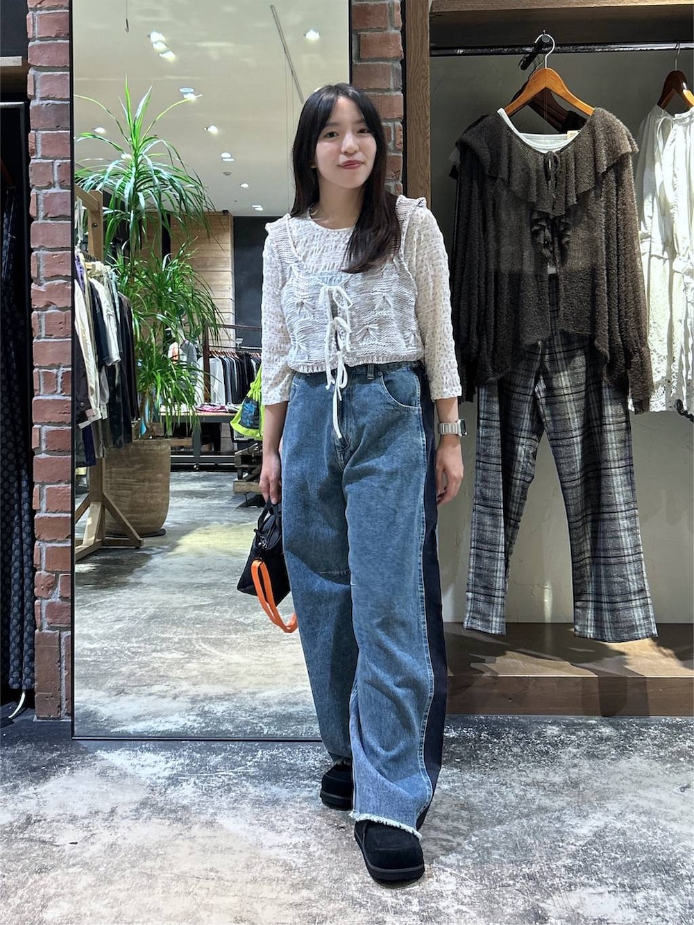 ホワイト系のTシャツ/カットソー、ホワイト系のベスト、ブラック系のトートバッグを着用したレディースの秋コーディネートの3枚目の写真