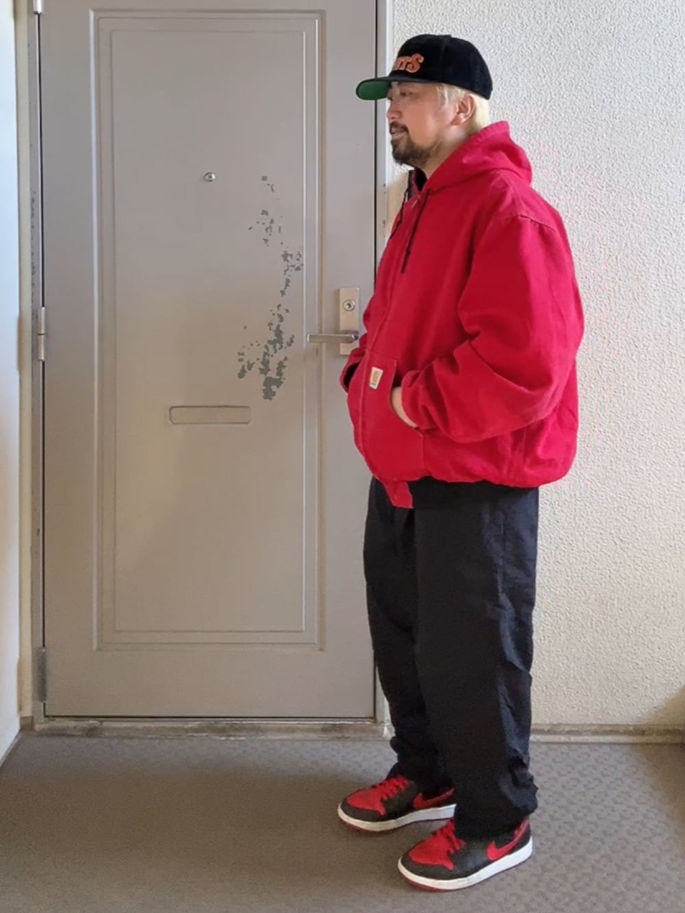 レッド系のジャケット/アウター、ブラック系のその他パンツ、レッド系のスニーカーを着用したメンズの秋コーディネートの2枚目の写真