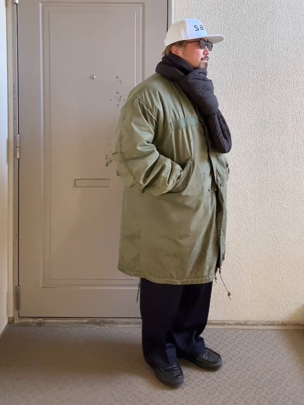 グリーン系のミリタリージャケット、その他のスラックス、ブラック系のスニーカーを着用したメンズの冬コーディネートの2枚目の写真