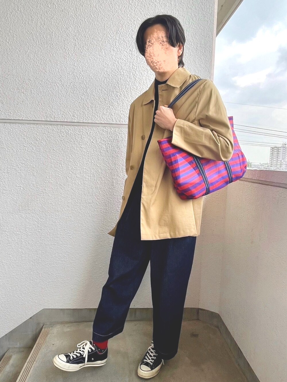 ブルー系のニット/セーター、ブラック系のカーディガン/ボレロ、ベージュ系のステンカラーコートを着用したメンズの春コーディネートの2枚目の写真