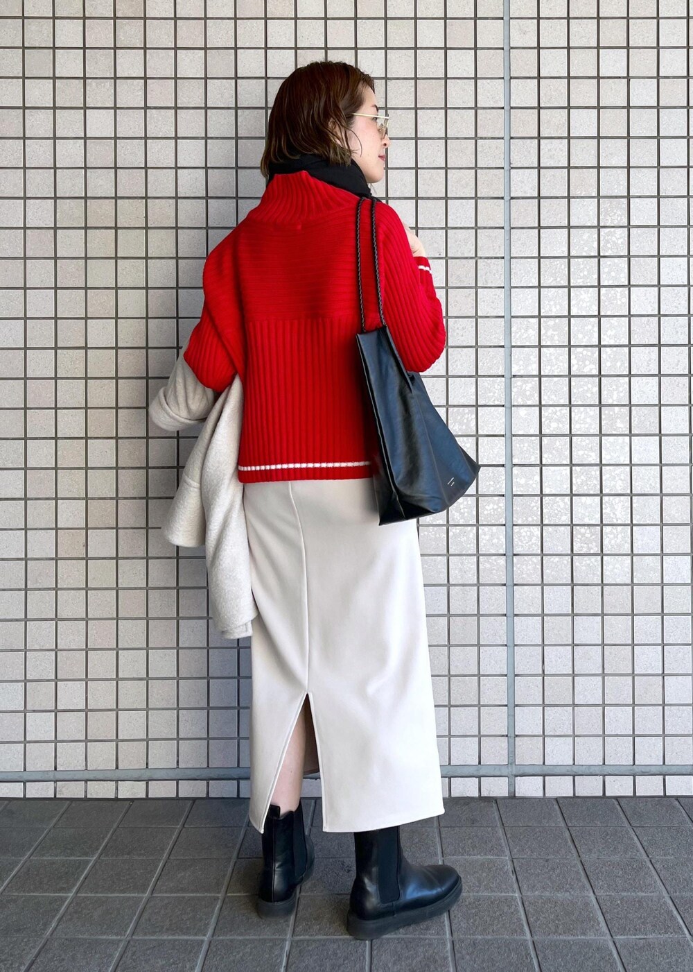 ブラック系のトートバッグ、レッド系のニット/セーター、ブラック系のブーツを着用したレディースの冬コーディネートの7枚目の写真