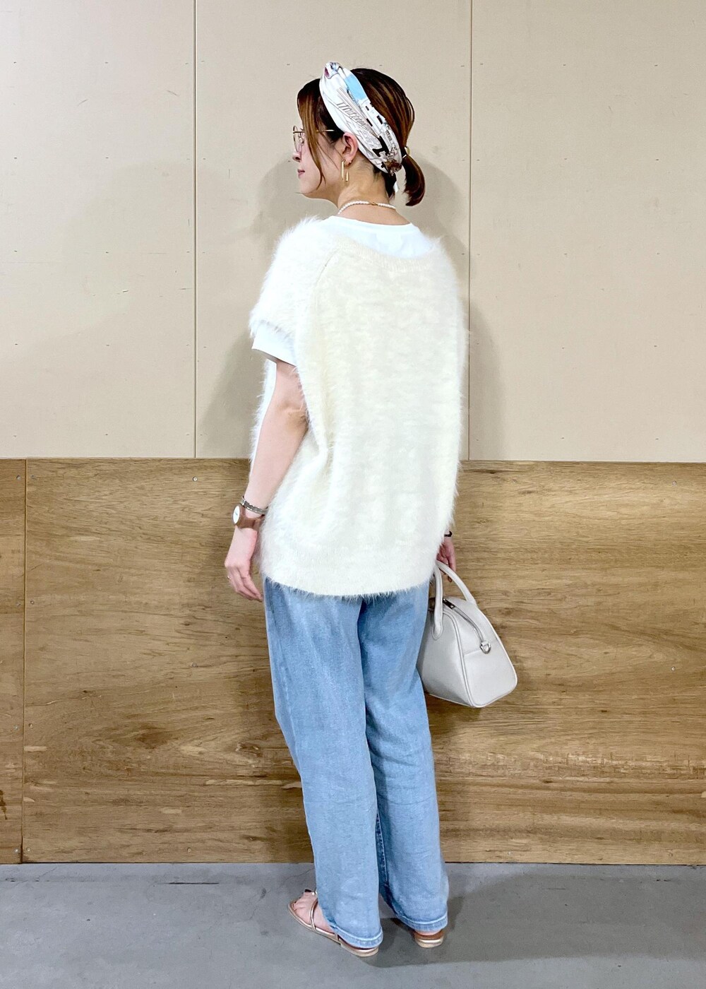 ベージュ系のボストンバッグ、ブルー系のデニムパンツ、ホワイト系のTシャツ/カットソーを着用したレディースの秋コーディネートの6枚目の写真