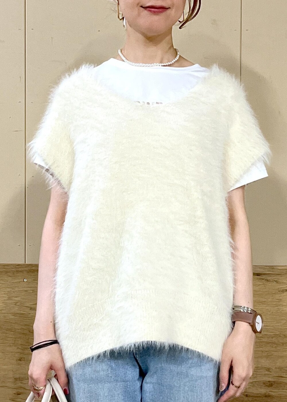 ベージュ系のボストンバッグ、ブルー系のデニムパンツ、ホワイト系のTシャツ/カットソーを着用したレディースの秋コーディネートの2枚目の写真