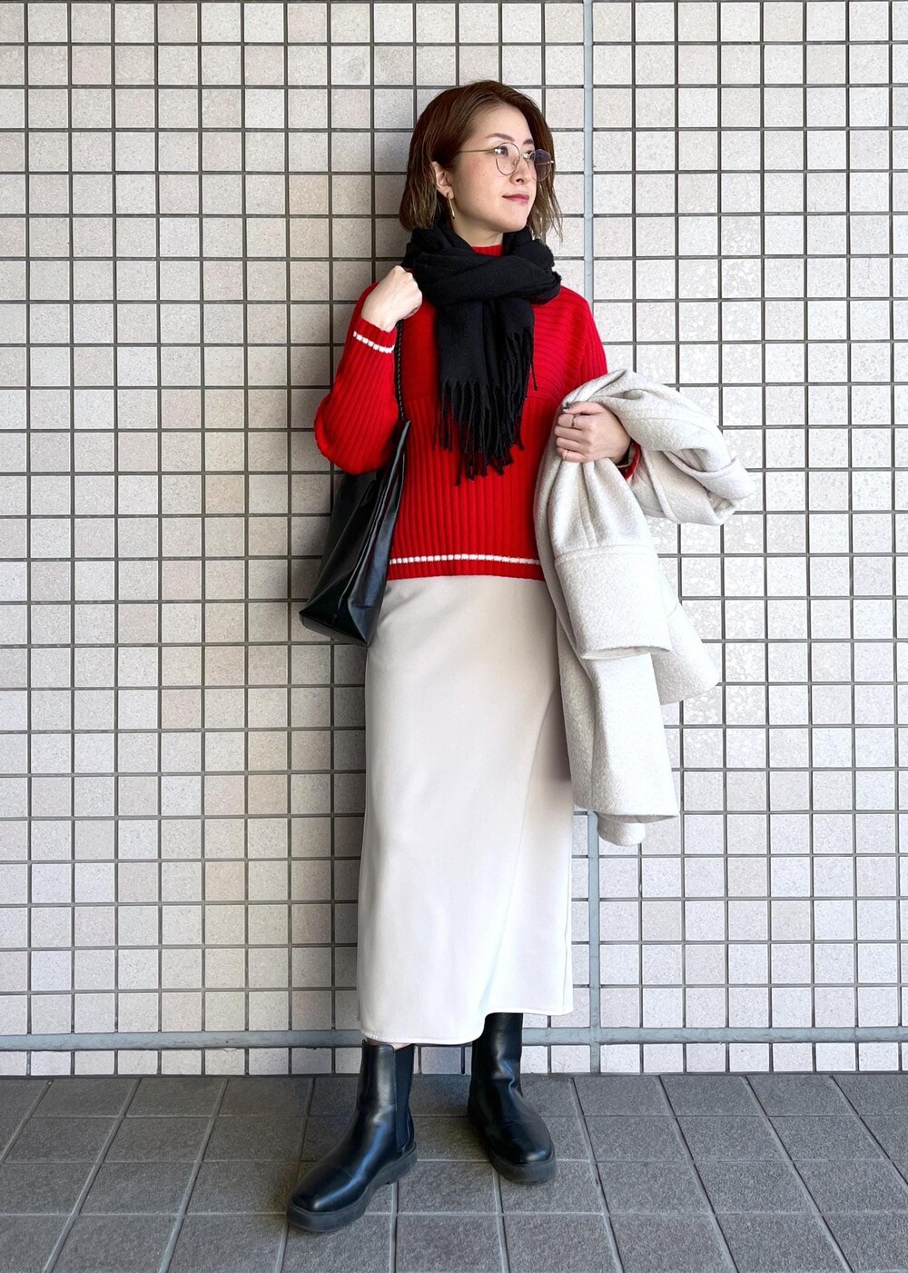 ブラック系のトートバッグ、レッド系のニット/セーター、ブラック系のブーツを着用したレディースの冬コーディネートの5枚目の写真