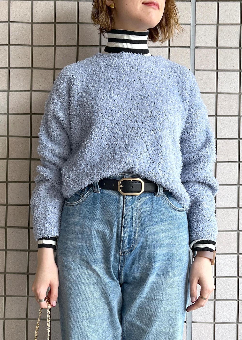 ブルー系のデニムパンツ、ブラック系のブーツ、ホワイト系のニット/セーターを着用したレディースの冬コーディネートの8枚目の写真