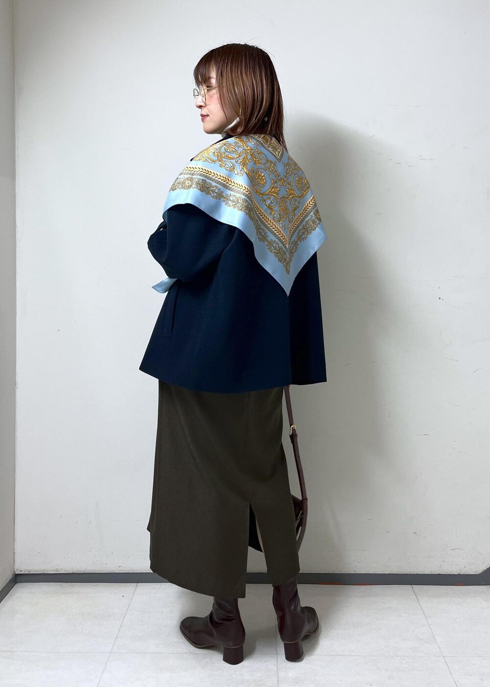 レッド系のショルダーバッグ、ホワイト系のニット/セーター、ブラウン系のブーツを着用したレディースの秋コーディネートの5枚目の写真