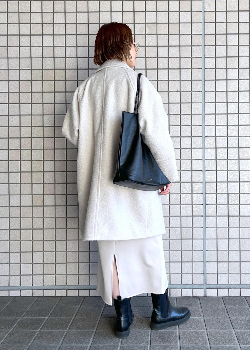 ブラック系のトートバッグ、レッド系のニット/セーター、ブラック系のブーツを着用したレディースの冬コーディネートの4枚目の写真