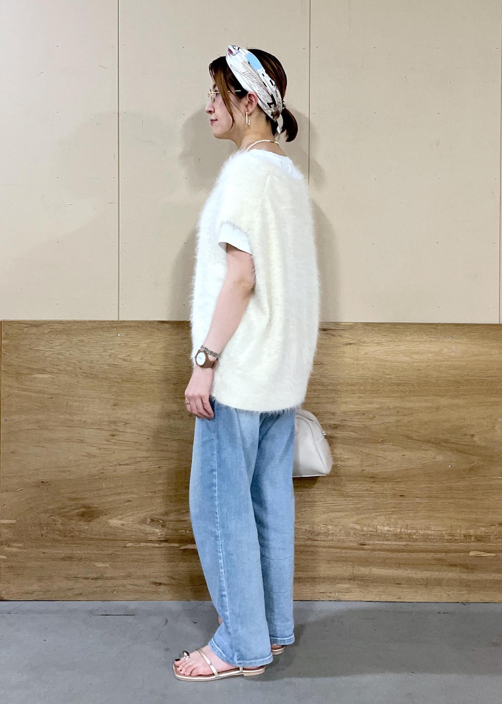 ベージュ系のボストンバッグ、ブルー系のデニムパンツ、ホワイト系のTシャツ/カットソーを着用したレディースの秋コーディネートの7枚目の写真