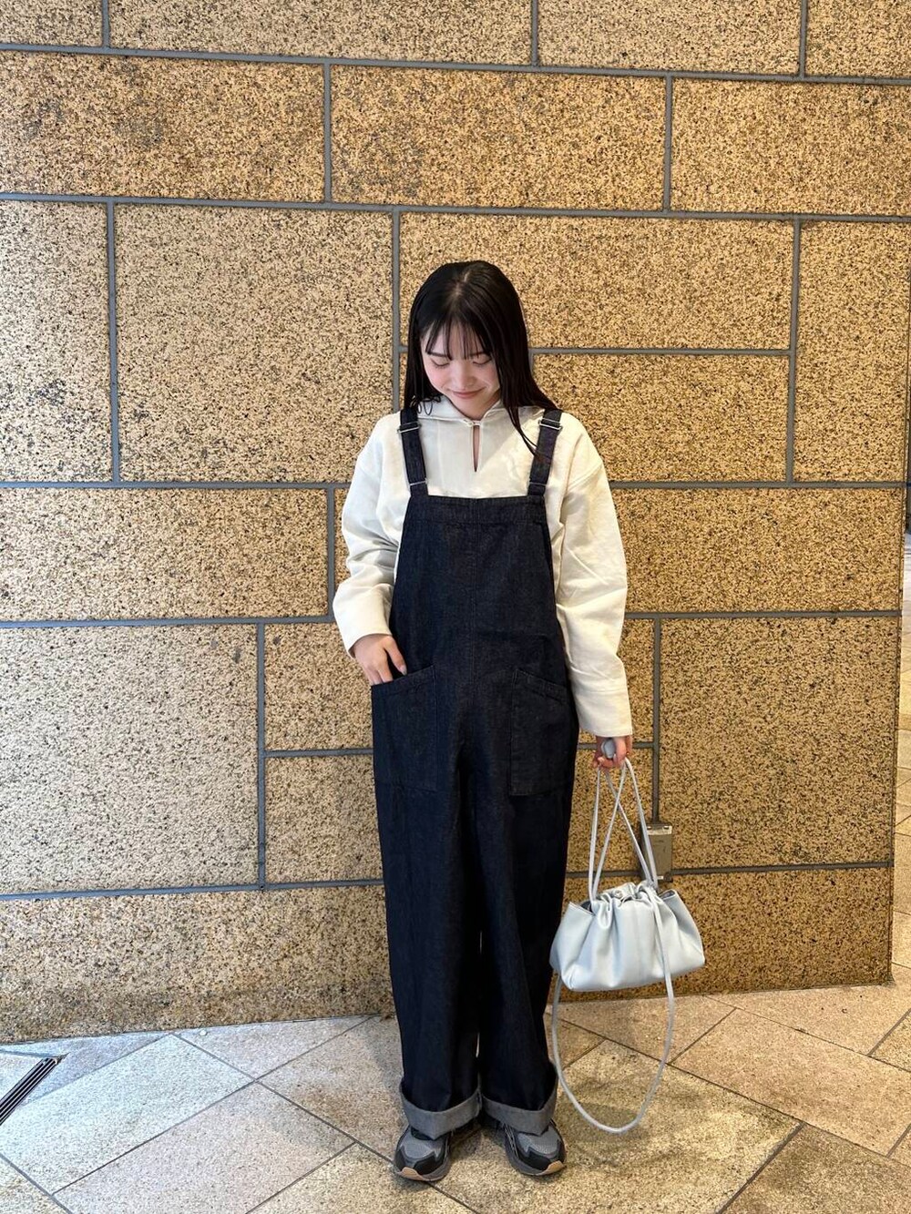 ブルー系のショルダーバッグ、ブルー系のサロペット/オーバーオール、ホワイト系のその他トップスを着用したレディースの冬コーディネートの2枚目の写真