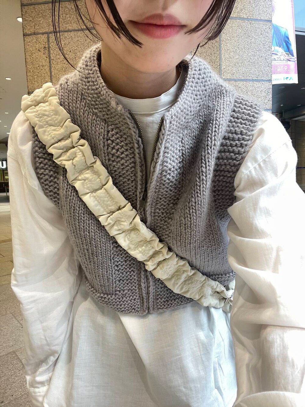 ブルー系のデニムパンツ、ブラック系のバレエシューズ、ホワイト系のショルダーバッグを着用したレディースの秋コーディネートの6枚目の写真