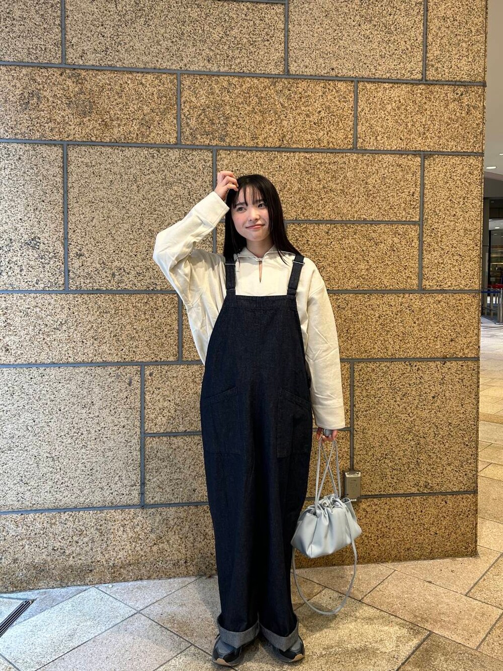 ブルー系のショルダーバッグ、ブルー系のサロペット/オーバーオール、ホワイト系のその他トップスを着用したレディースの冬コーディネートの5枚目の写真