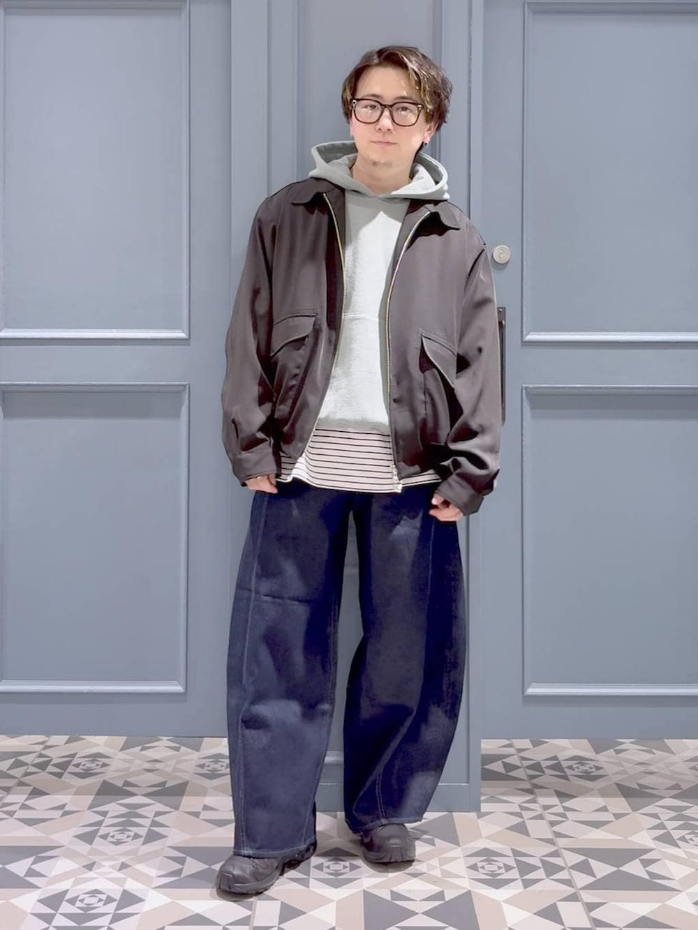 ブラック系のスニーカー、グリーン系のパーカー、ブラック系のブルゾンを着用したメンズの春コーディネートの4枚目の写真