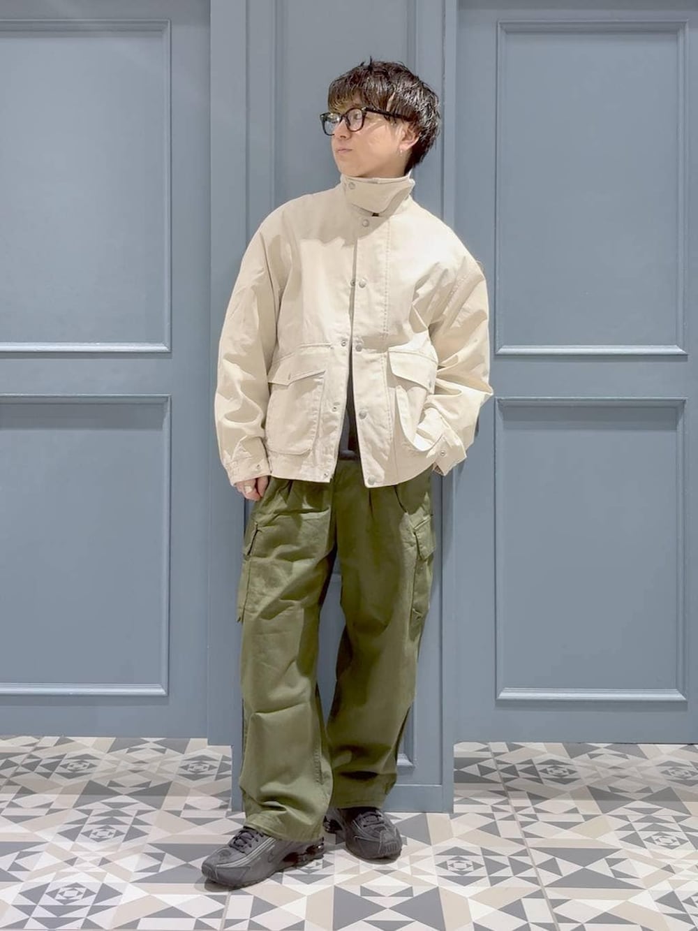 グリーン系のカーゴパンツ、ホワイト系のブルゾン、ブラック系のスウェットを着用したメンズの冬コーディネートの4枚目の写真