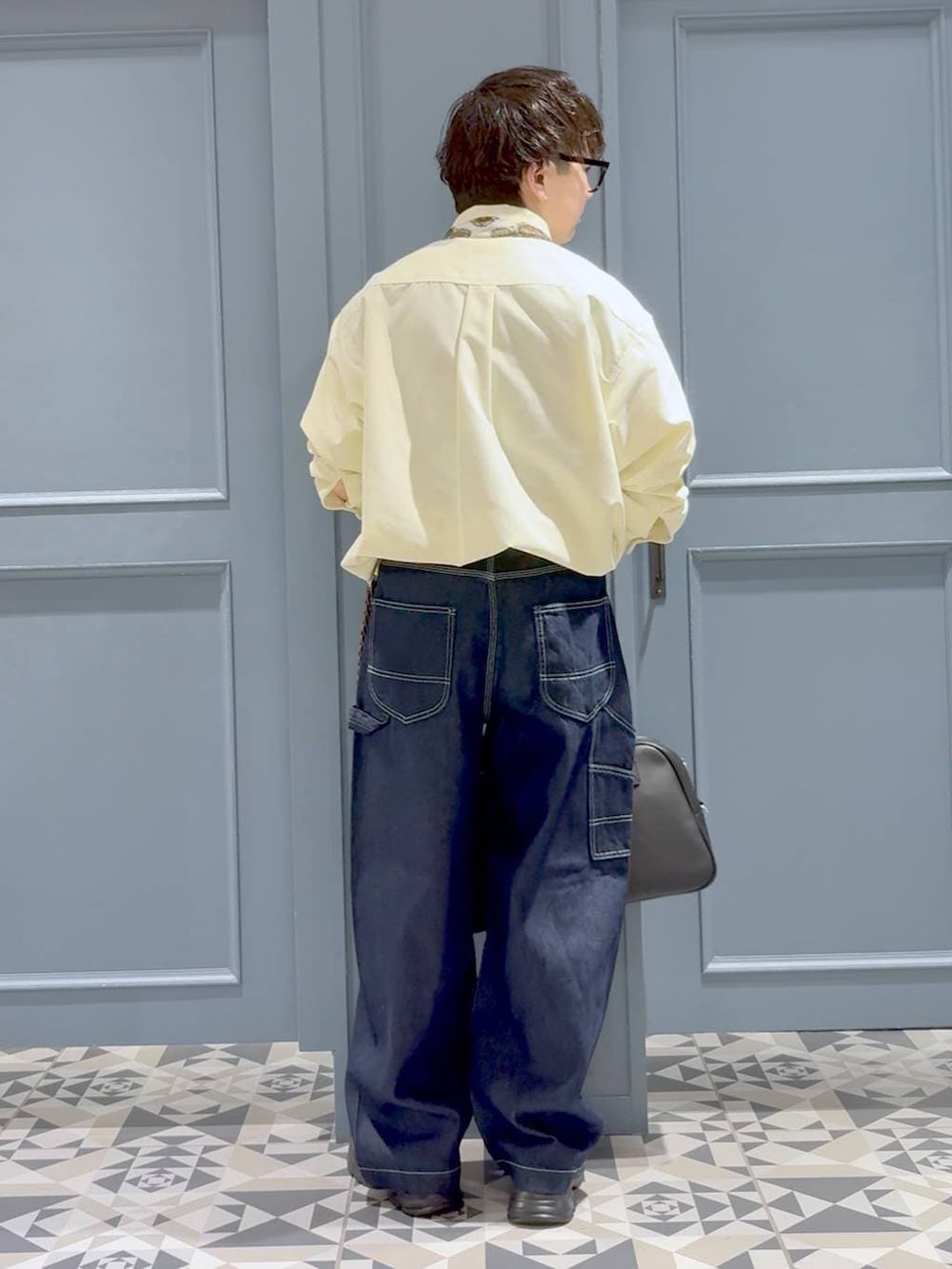 ブラック系のローファー、イエロー系のシャツ/ブラウス、ブルー系のデニムパンツを着用したメンズの春コーディネートの3枚目の写真