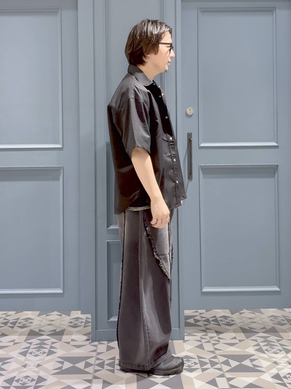 ブラック系のTシャツ/カットソー、ブラック系のデニムパンツ、ブラック系のスニーカーを着用したメンズの夏コーディネートの2枚目の写真
