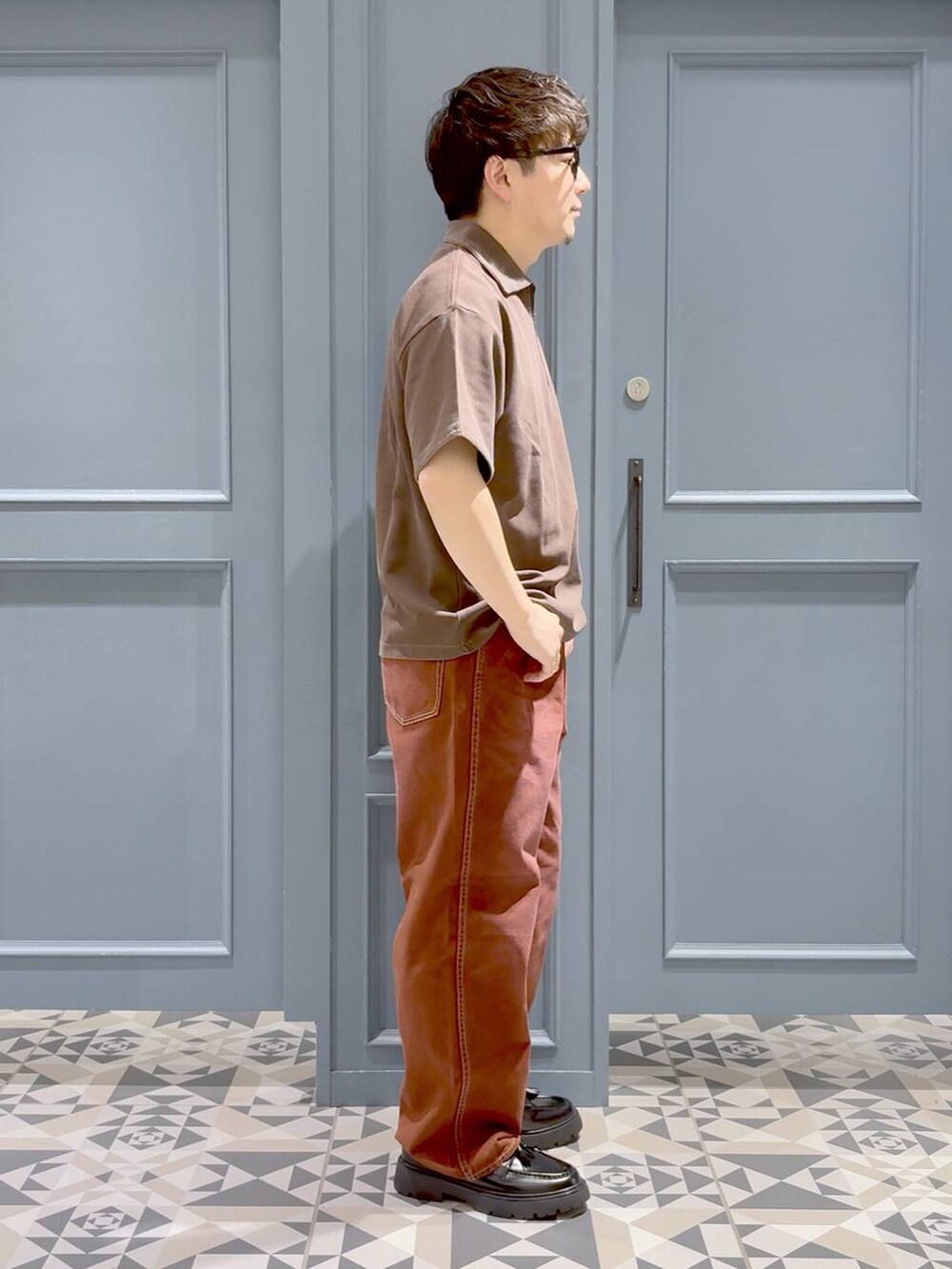 ブラック系のドレスシューズ、ブラウン系のデニムパンツ、ブラウン系のTシャツ/カットソーを着用したメンズの春コーディネートの2枚目の写真