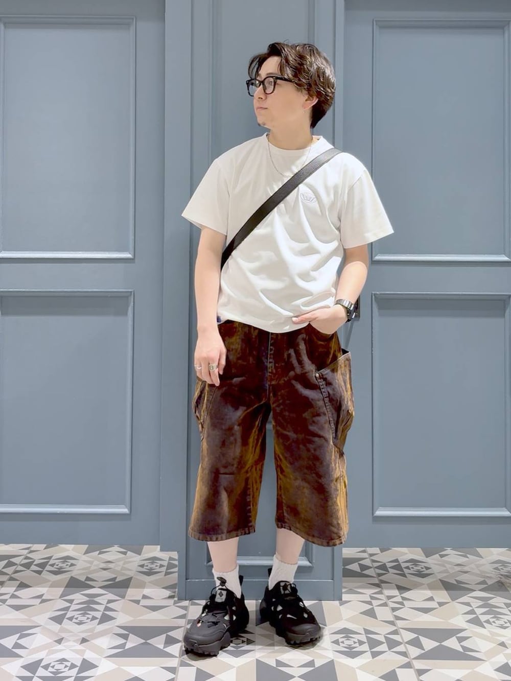 ブラック系のサンダル、ブラック系のショルダーバッグ、ホワイト系のTシャツ/カットソーを着用したメンズの夏コーディネートの4枚目の写真