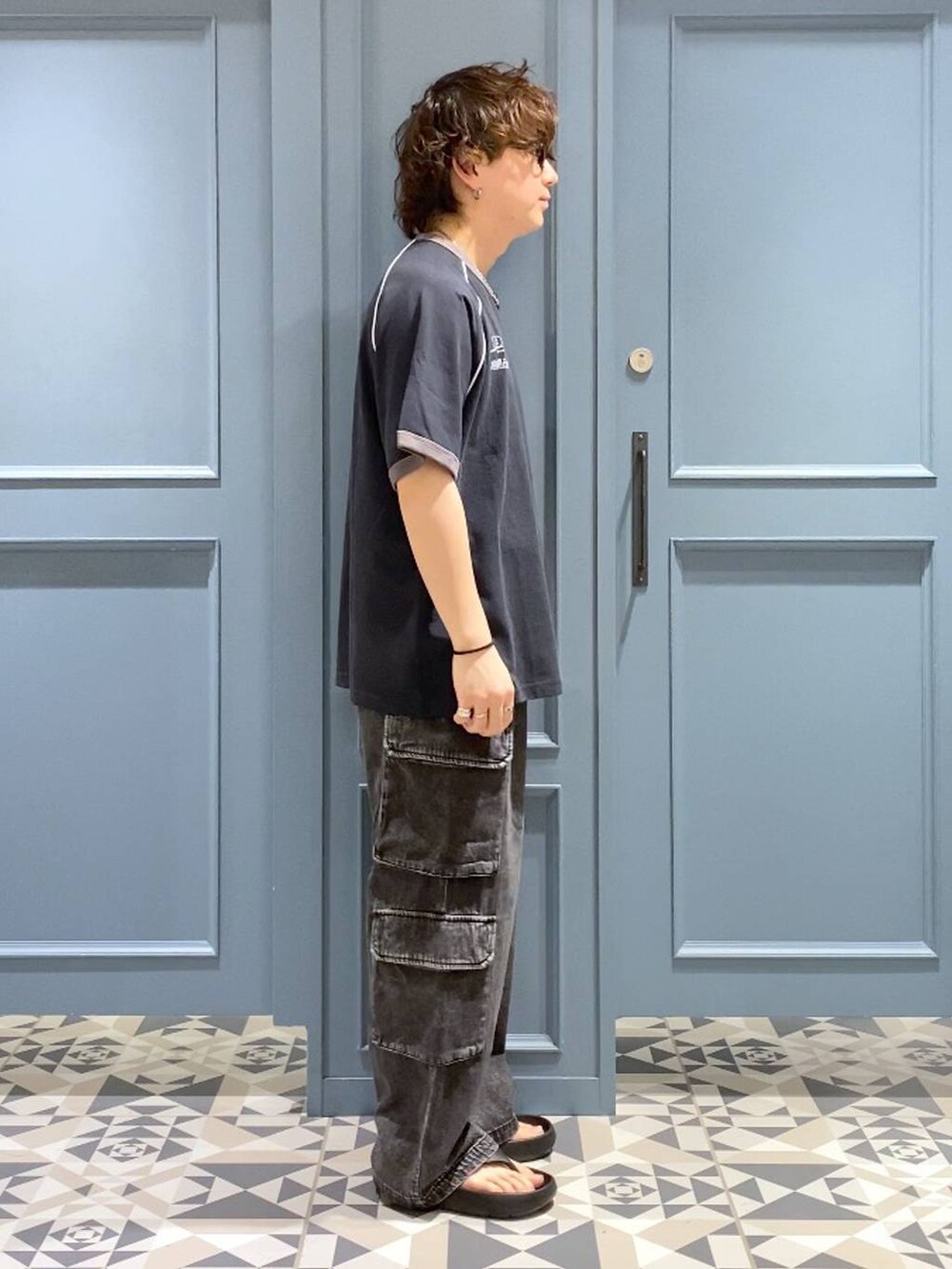 ブラック系のサンダル、ブラック系のデニムパンツ、ブラック系のTシャツ/カットソーを着用したメンズの夏コーディネートの3枚目の写真