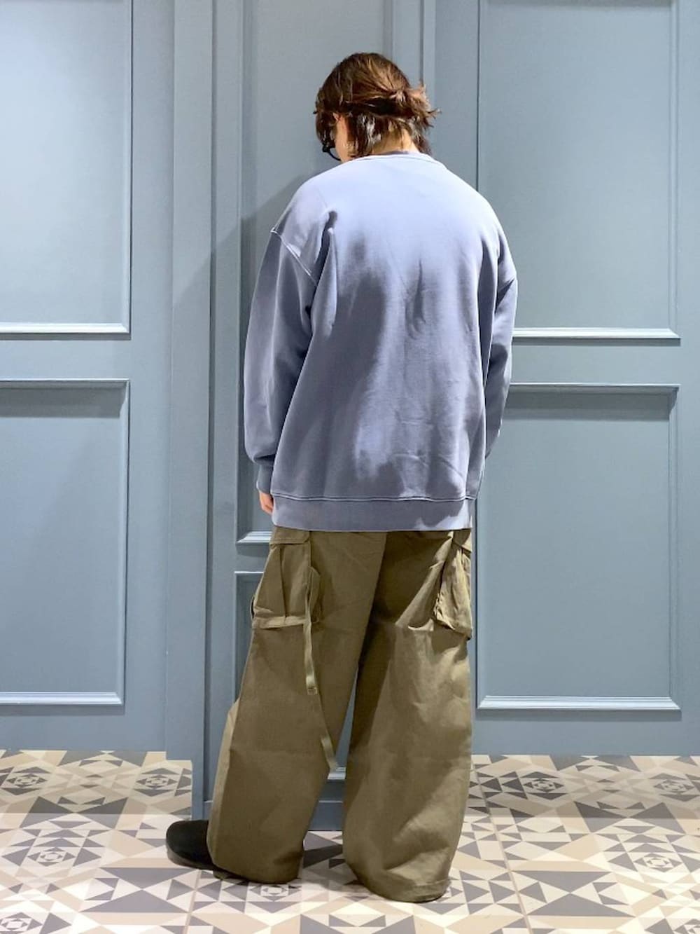 グリーン系のカーゴパンツ、ブルー系のスウェット、ブラック系のサングラスを着用したメンズの冬コーディネートの3枚目の写真