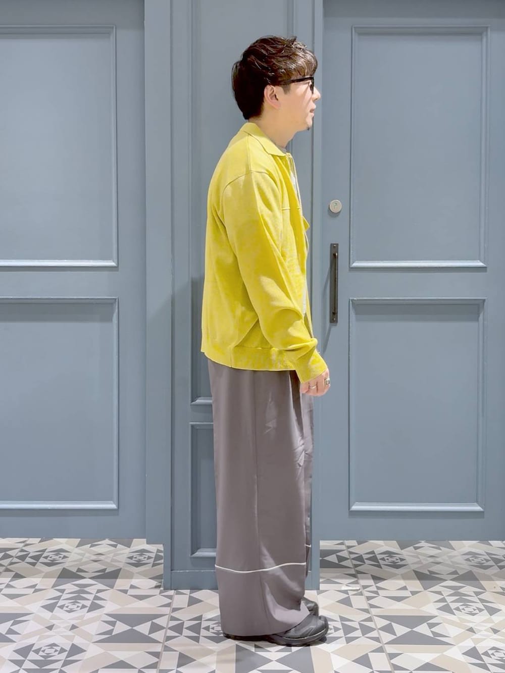 ブラック系のスニーカー、ホワイト系のTシャツ/カットソー、イエロー系のシャツ/ブラウスを着用したメンズの春コーディネートの2枚目の写真