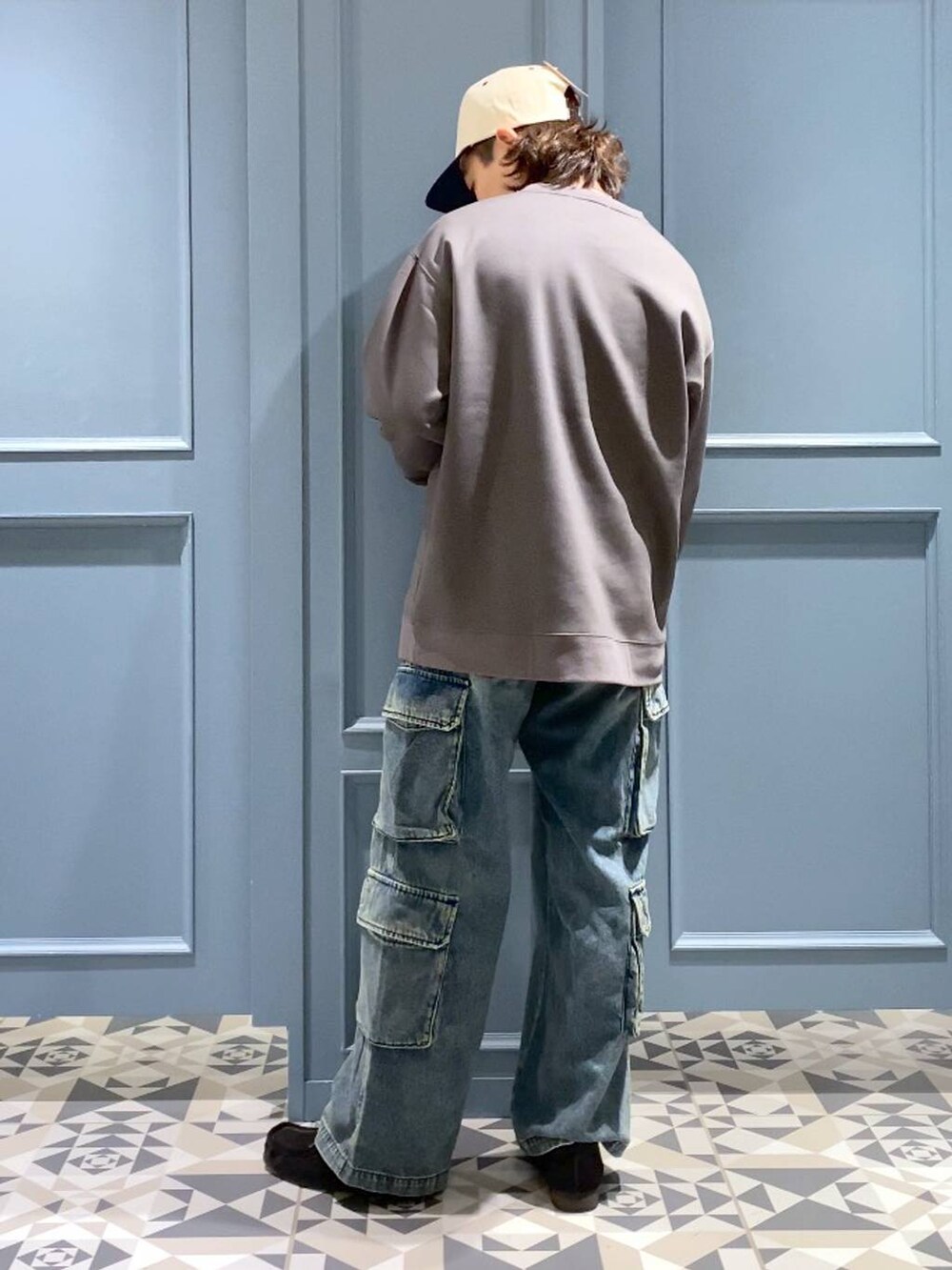 ブルー系のデニムパンツ、ブラック系のモカシン/デッキシューズ、グレー系のスウェットを着用したメンズの冬コーディネートの3枚目の写真