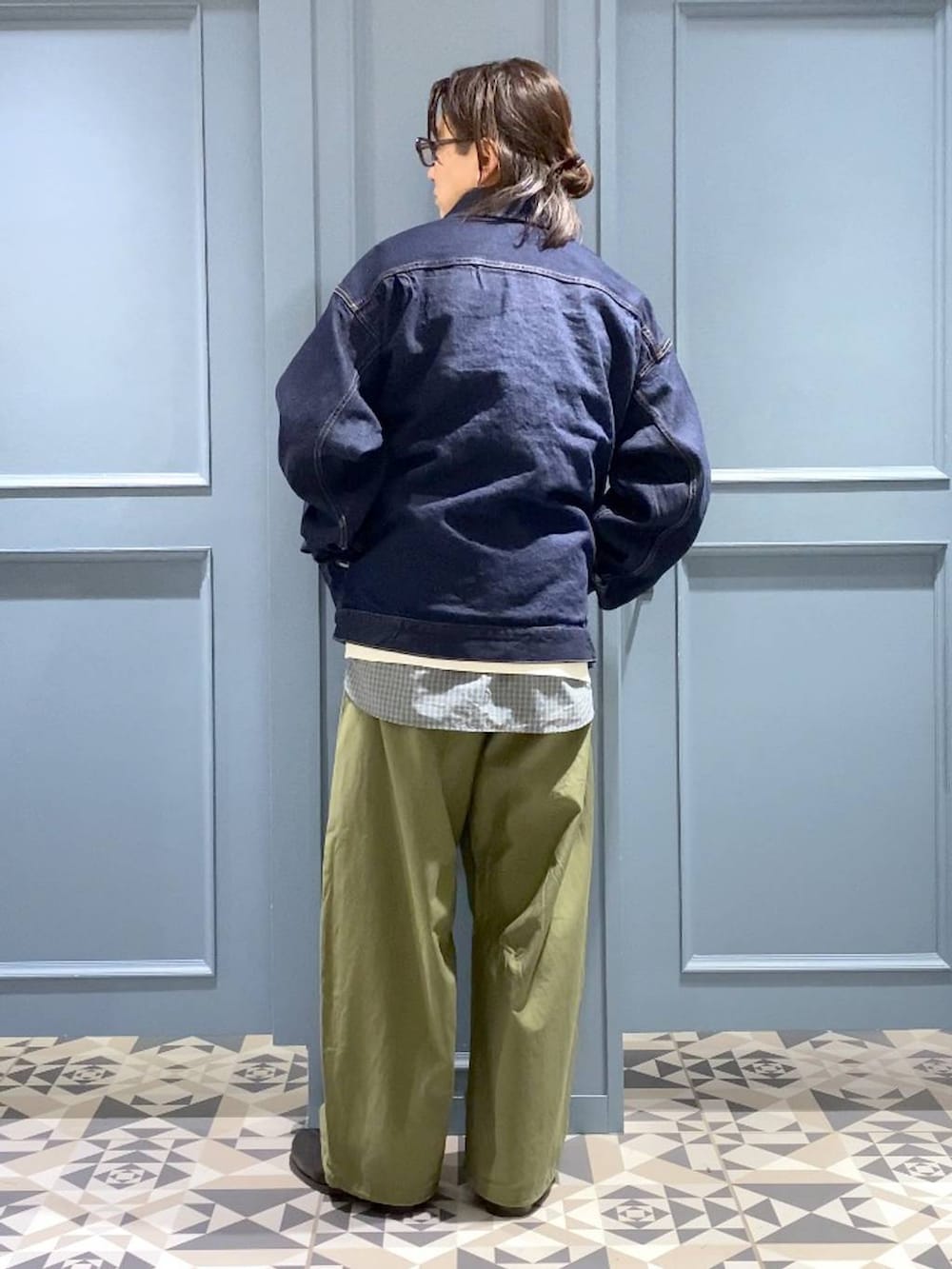 ブラック系のブーツ、グリーン系のカーゴパンツ、ブルー系のデニムジャケットを着用したメンズの春コーディネートの3枚目の写真