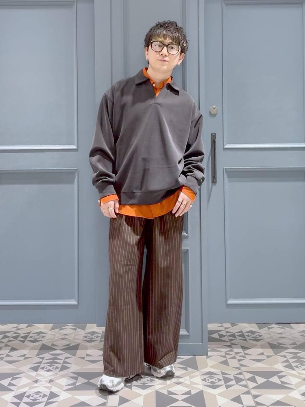 オレンジ系のシャツ/ブラウス、ブラウン系のスラックス、ブラック系のスウェットを着用したメンズの冬コーディネートの4枚目の写真