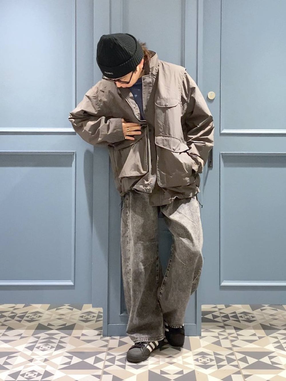 グレー系のデニムパンツ、グレー系のブルゾン、ブルー系のニット/セーターを着用したメンズの秋コーディネートの4枚目の写真