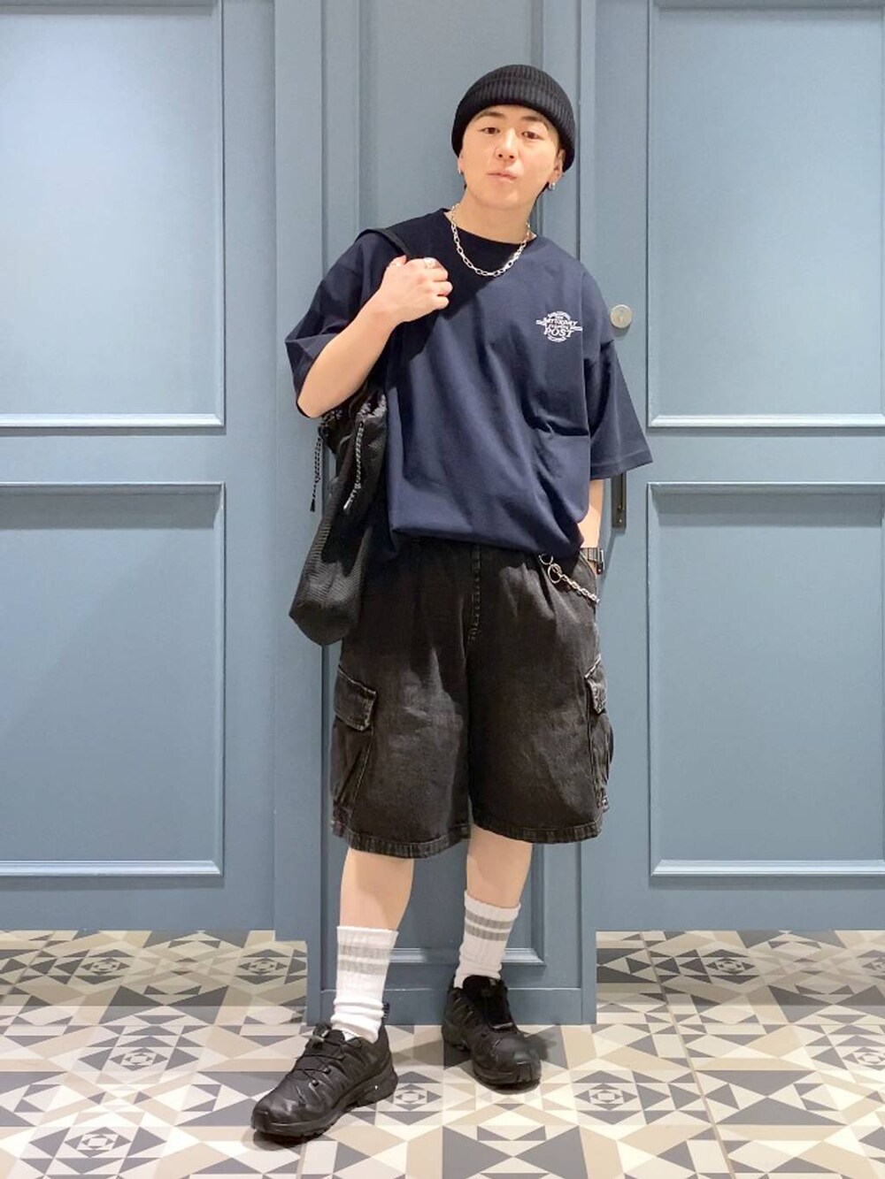 ブラック系のスニーカー、グレー系のカーゴパンツ、ブラック系のトートバッグを着用したメンズの春コーディネートの4枚目の写真