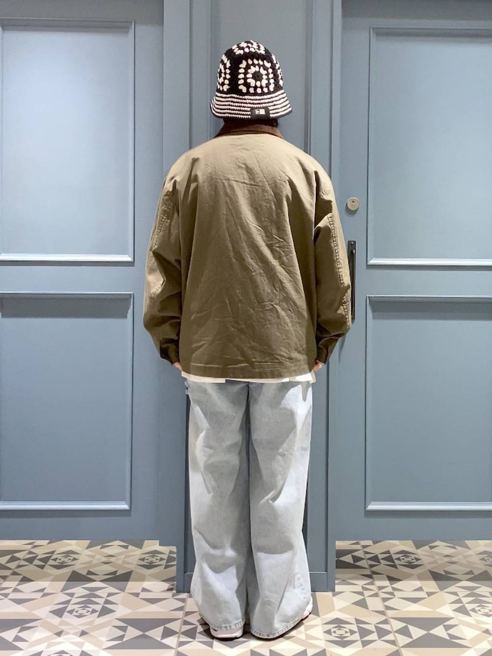 ホワイト系のスニーカー、ブルー系のデニムパンツ、ホワイト系のTシャツ/カットソーを着用したメンズの秋コーディネートの3枚目の写真