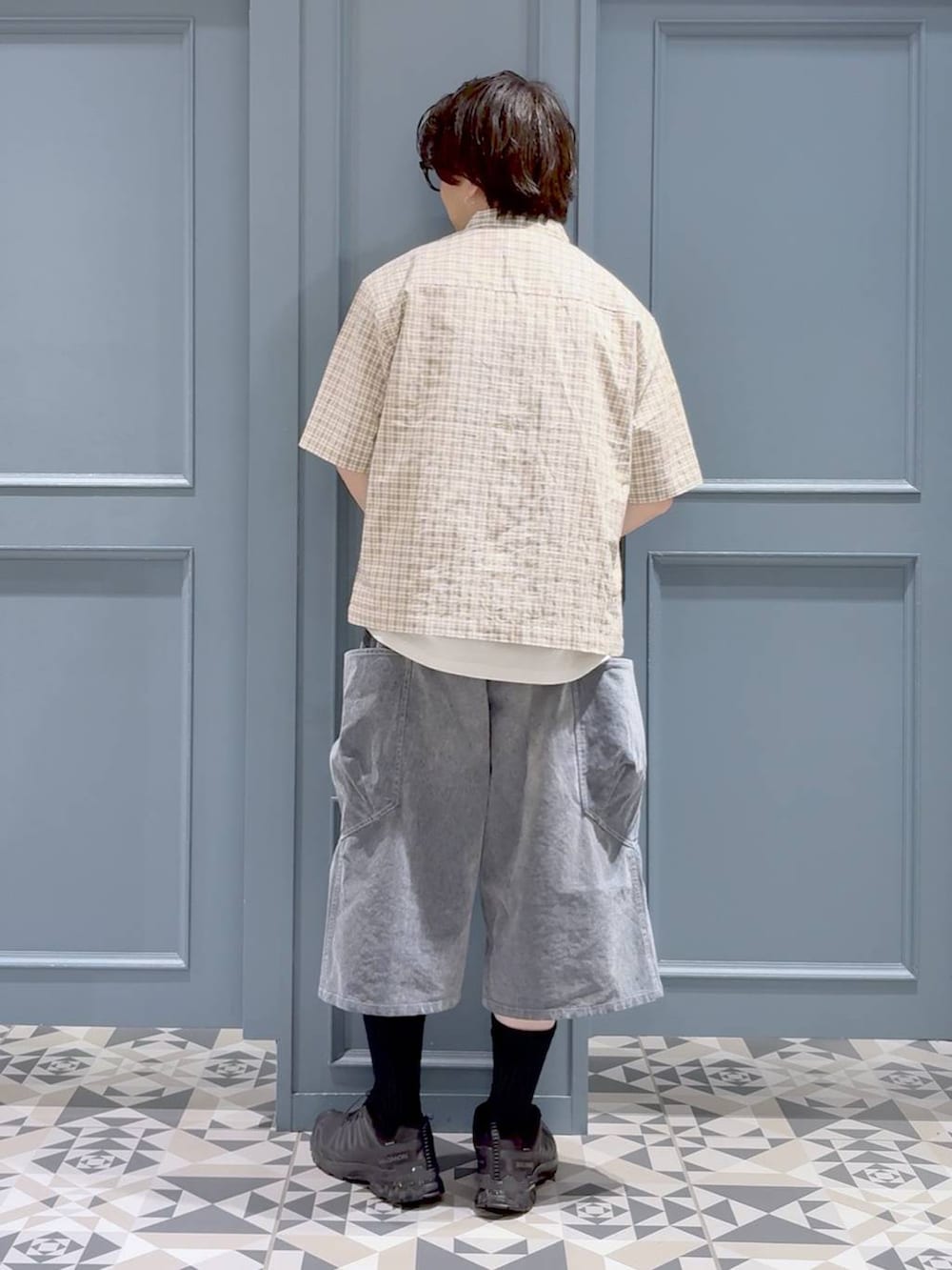 ブラック系のスニーカー、ホワイト系のTシャツ/カットソー、グレー系のデニムパンツを着用したメンズの夏コーディネートの3枚目の写真