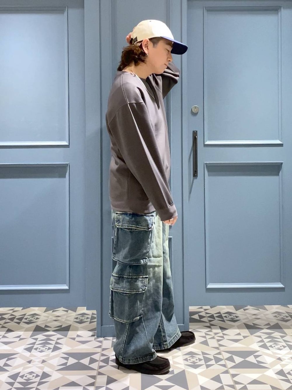 ブルー系のデニムパンツ、ブラック系のモカシン/デッキシューズ、グレー系のスウェットを着用したメンズの冬コーディネートの2枚目の写真