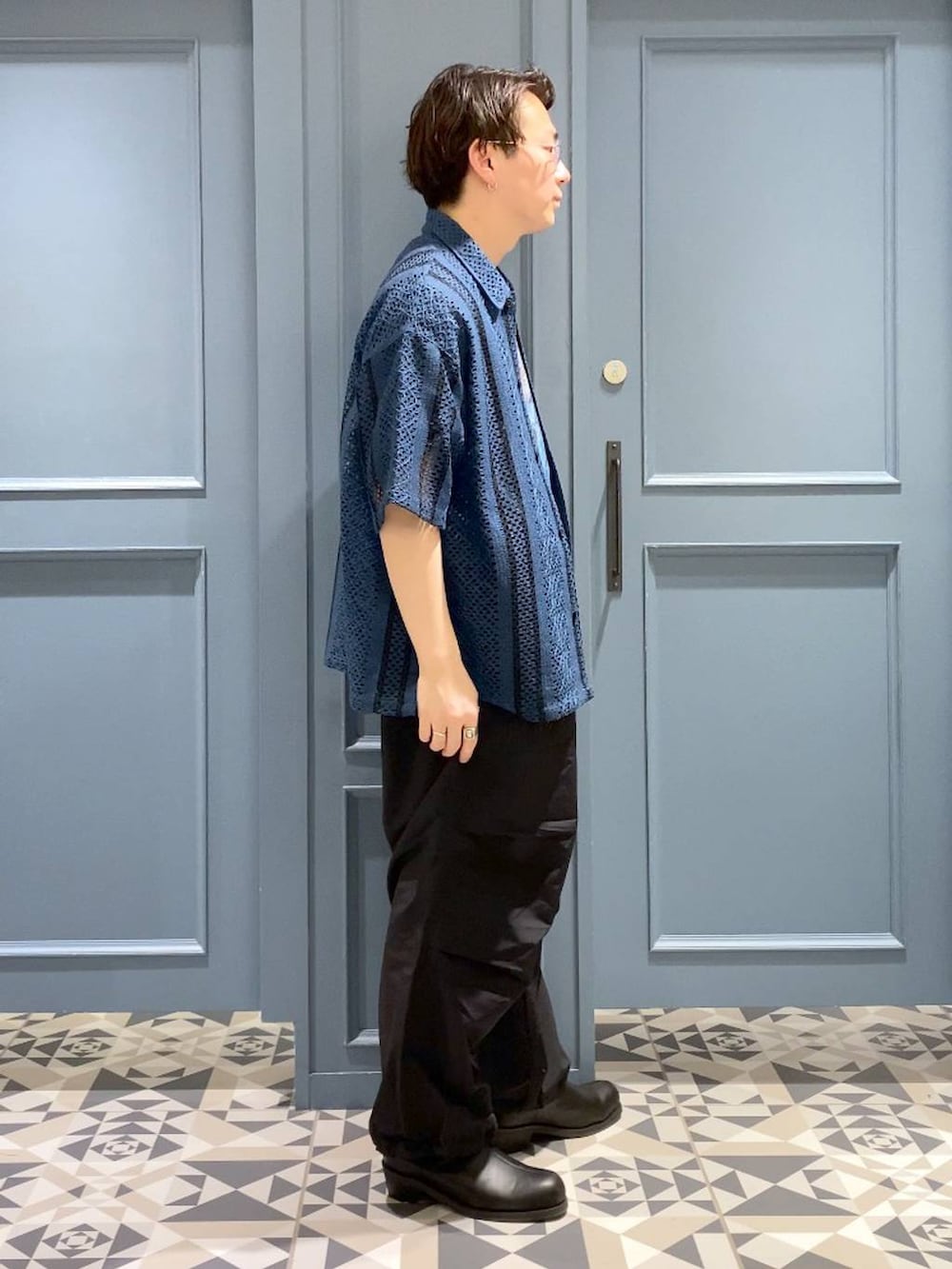 ブラック系のブーツ、ブラック系のカーゴパンツ、ブルー系のシャツ/ブラウスを着用したメンズの春コーディネートの2枚目の写真