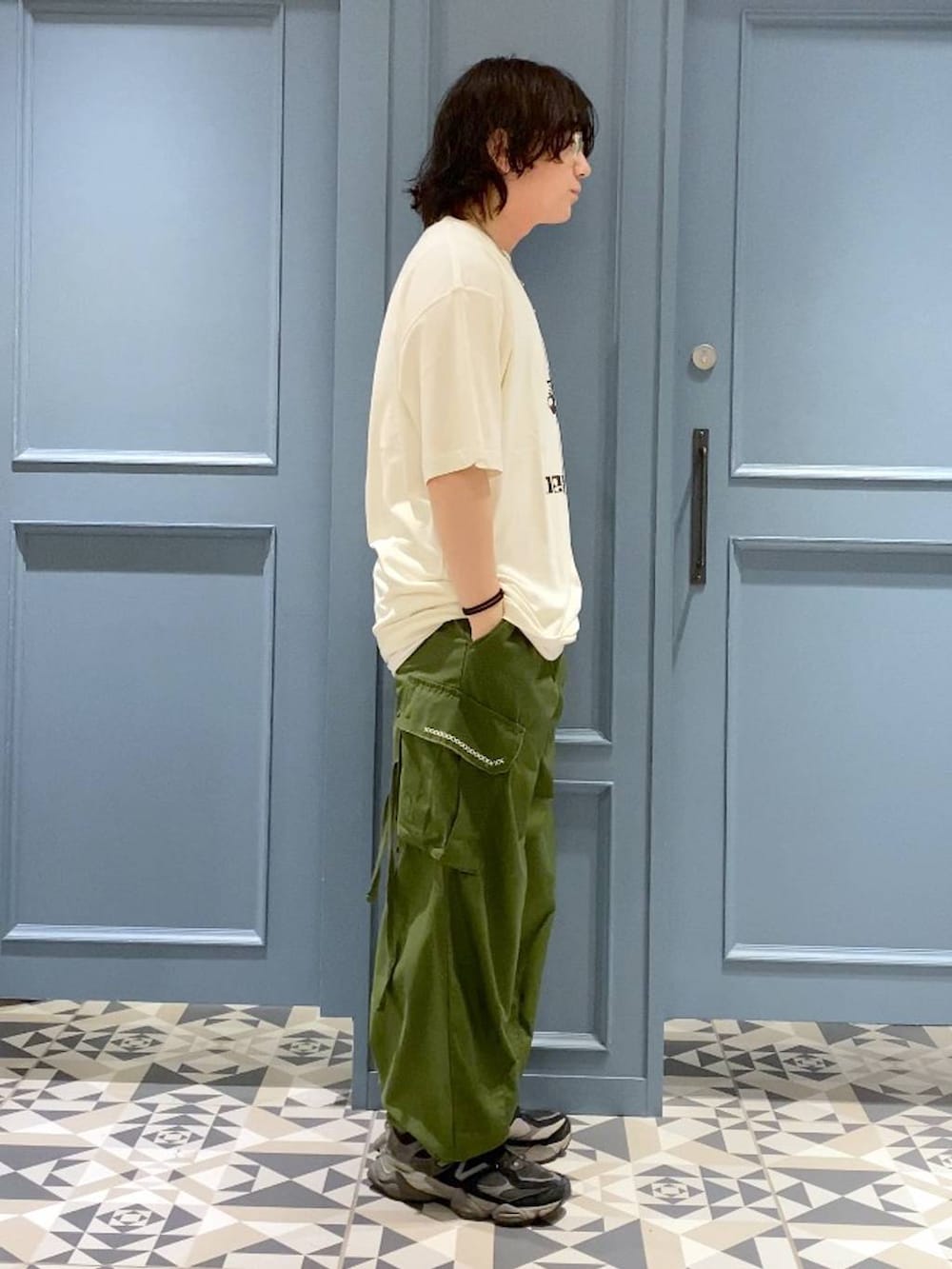 グリーン系のカーゴパンツ、ブラック系のTシャツ/カットソー、ホワイト系のネックレスを着用したメンズの春コーディネートの2枚目の写真