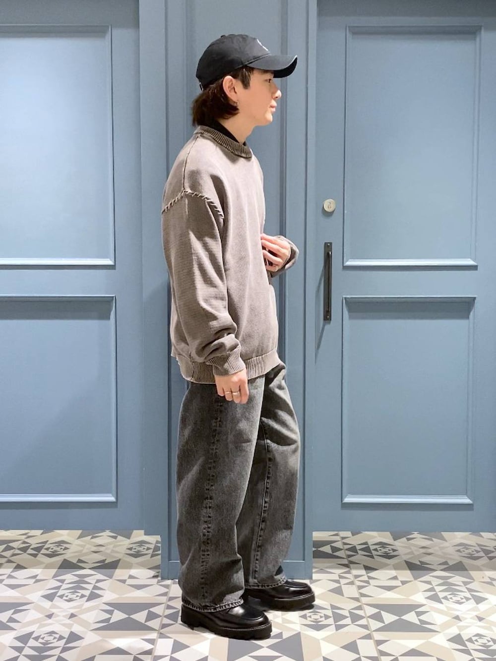 ブラック系のドレスシューズ、ブラック系のTシャツ/カットソー、グレー系のデニムパンツを着用したメンズの春コーディネートの2枚目の写真